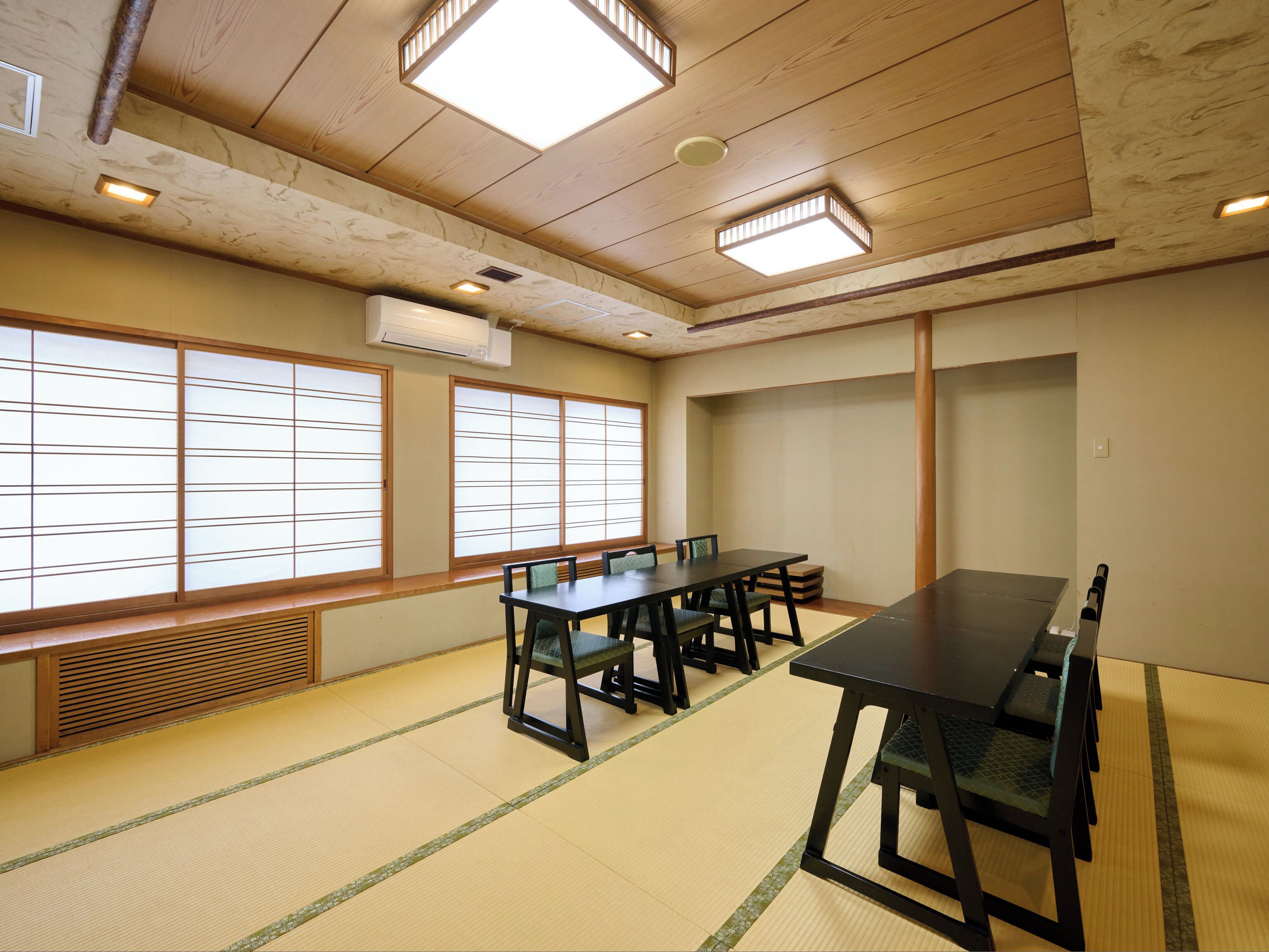 Una tradizionale stanza giapponese con pavimento in tatami, un tavolino e porte scorrevoli.