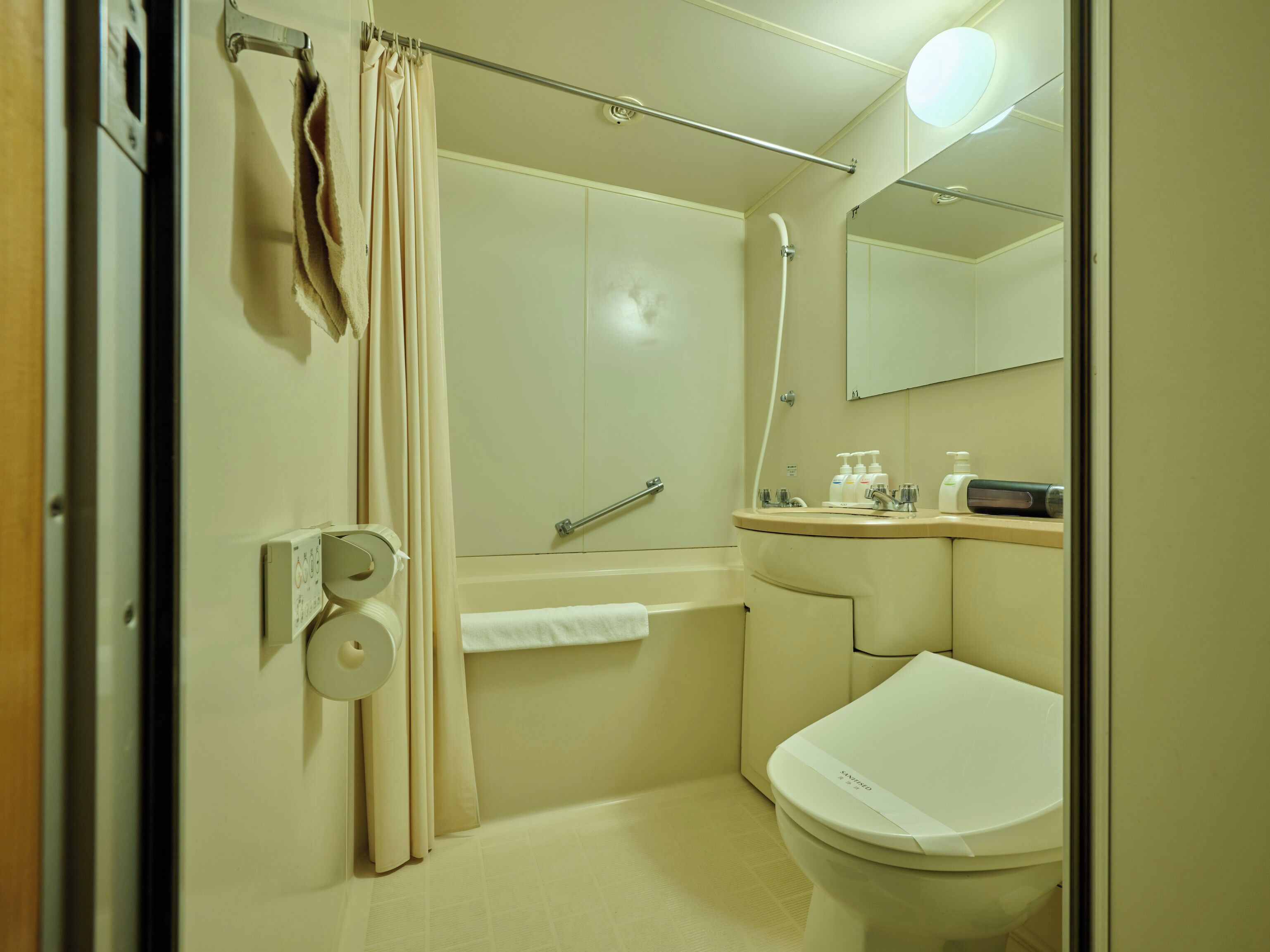 Ein Badezimmer mit Badewanne, Toilette, Waschbecken und Spiegel.
