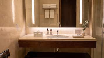 A modern bathroom with a large mirror, a sink, and a toilet.