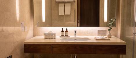 A modern bathroom with a large mirror, a sink, and a toilet.