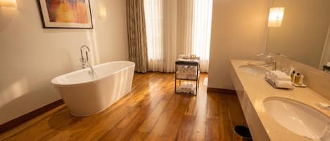 A modern bathroom with a freestanding bathtub, a vanity with a sink, and a towel rack.