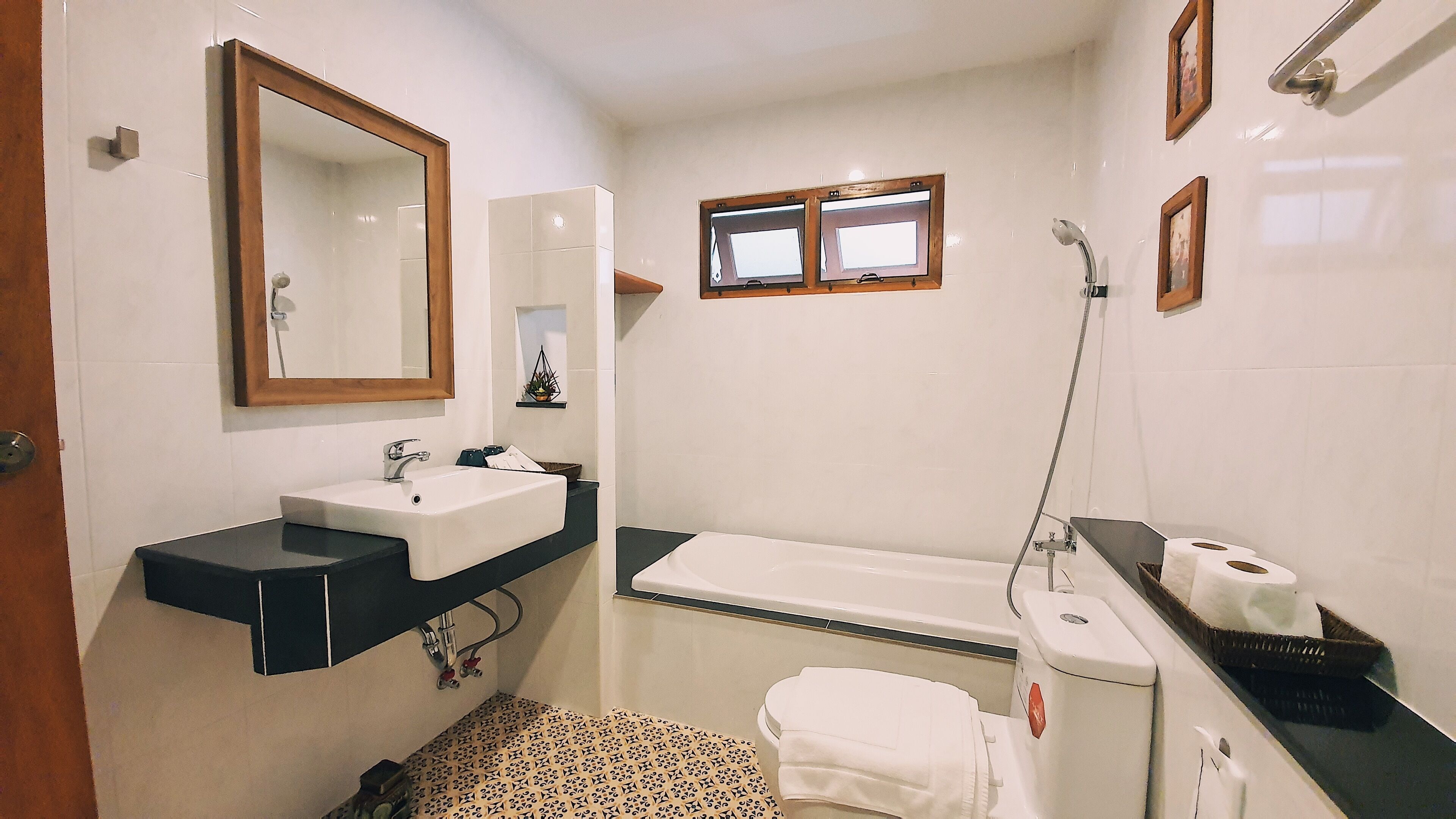 A bathroom with a sink, mirror, shower, and toilet.