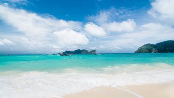 Di pantai, kursi berjemur, payung pantai, dan handuk pantai
