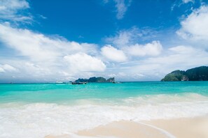 En la playa, camastros, sombrillas y toallas de playa 