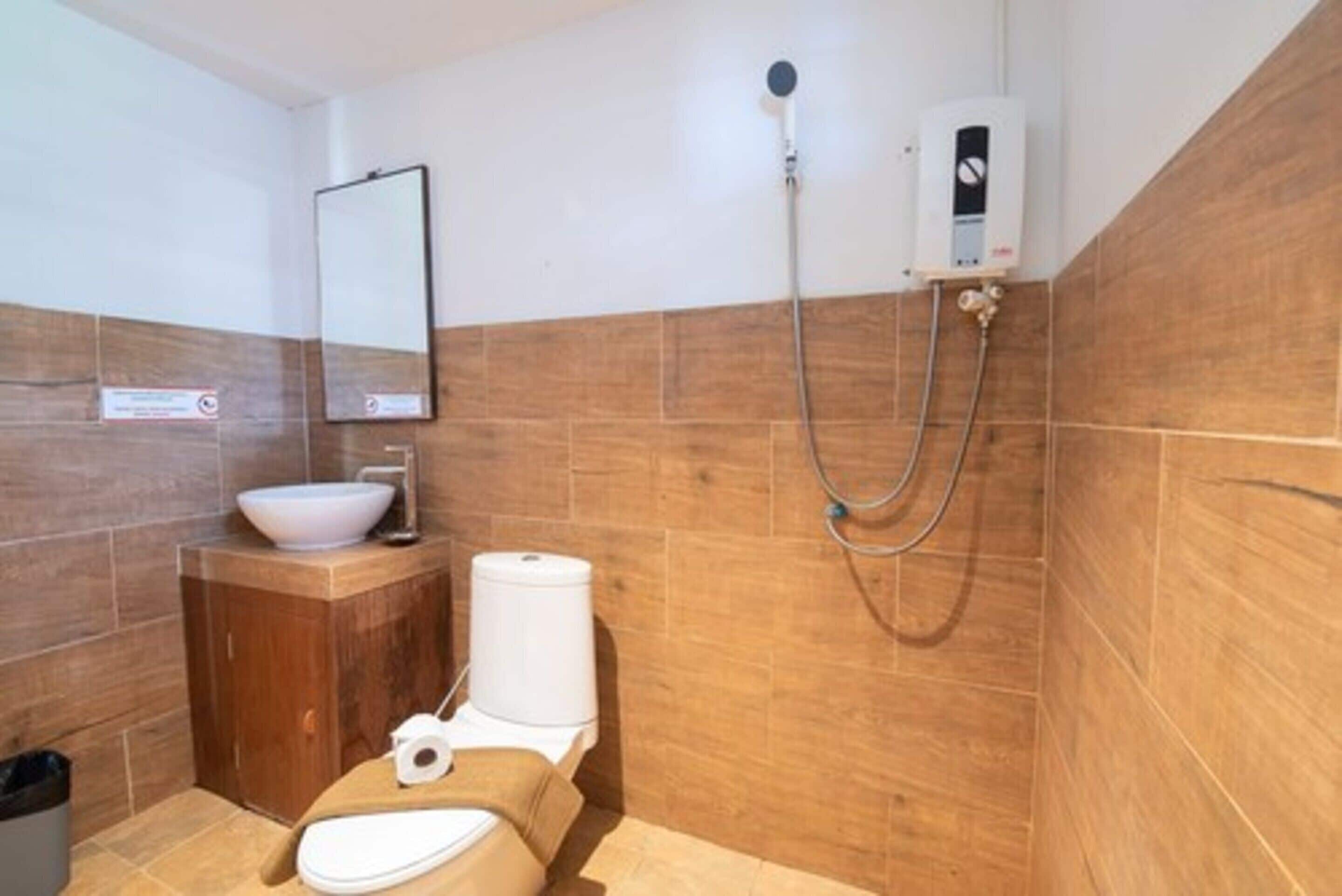 A small bathroom with a toilet, sink, and shower.
