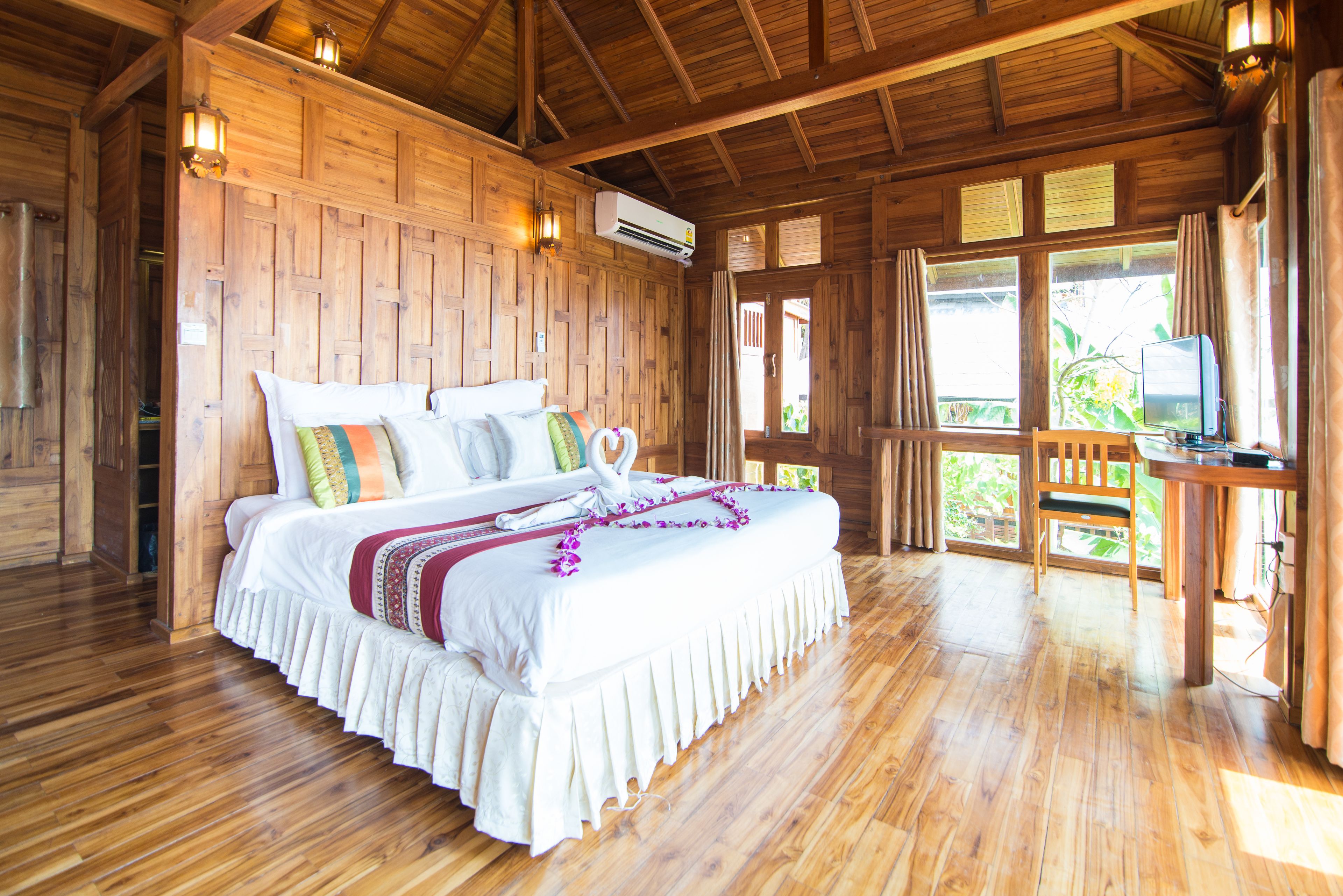 Una habitación de madera con una cama, una mesa y una silla.