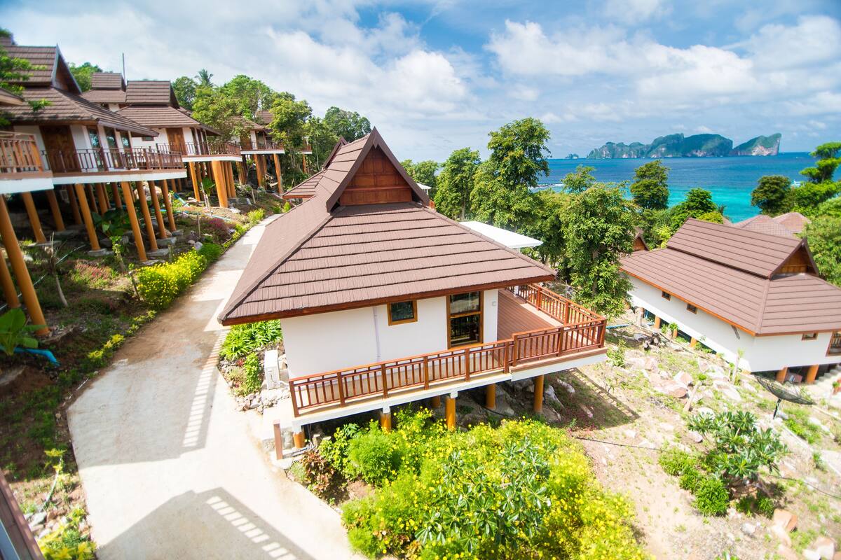 Un complexe hôtelier comprenant plusieurs bâtiments de style bungalow, chacun doté d’un balcon et offrant une vue sur la mer.