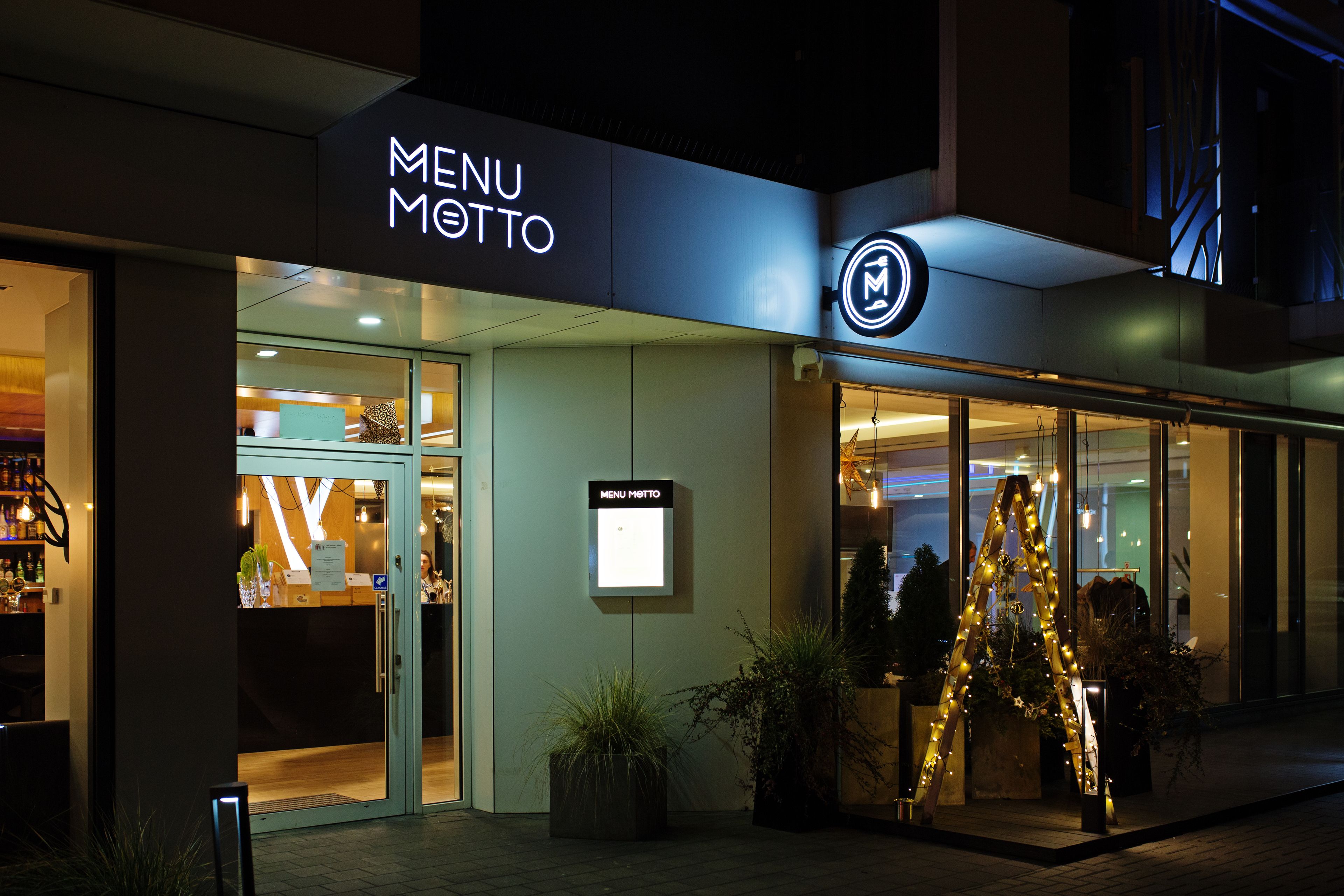 A modern building with a 'MENU' sign and a glass entrance.