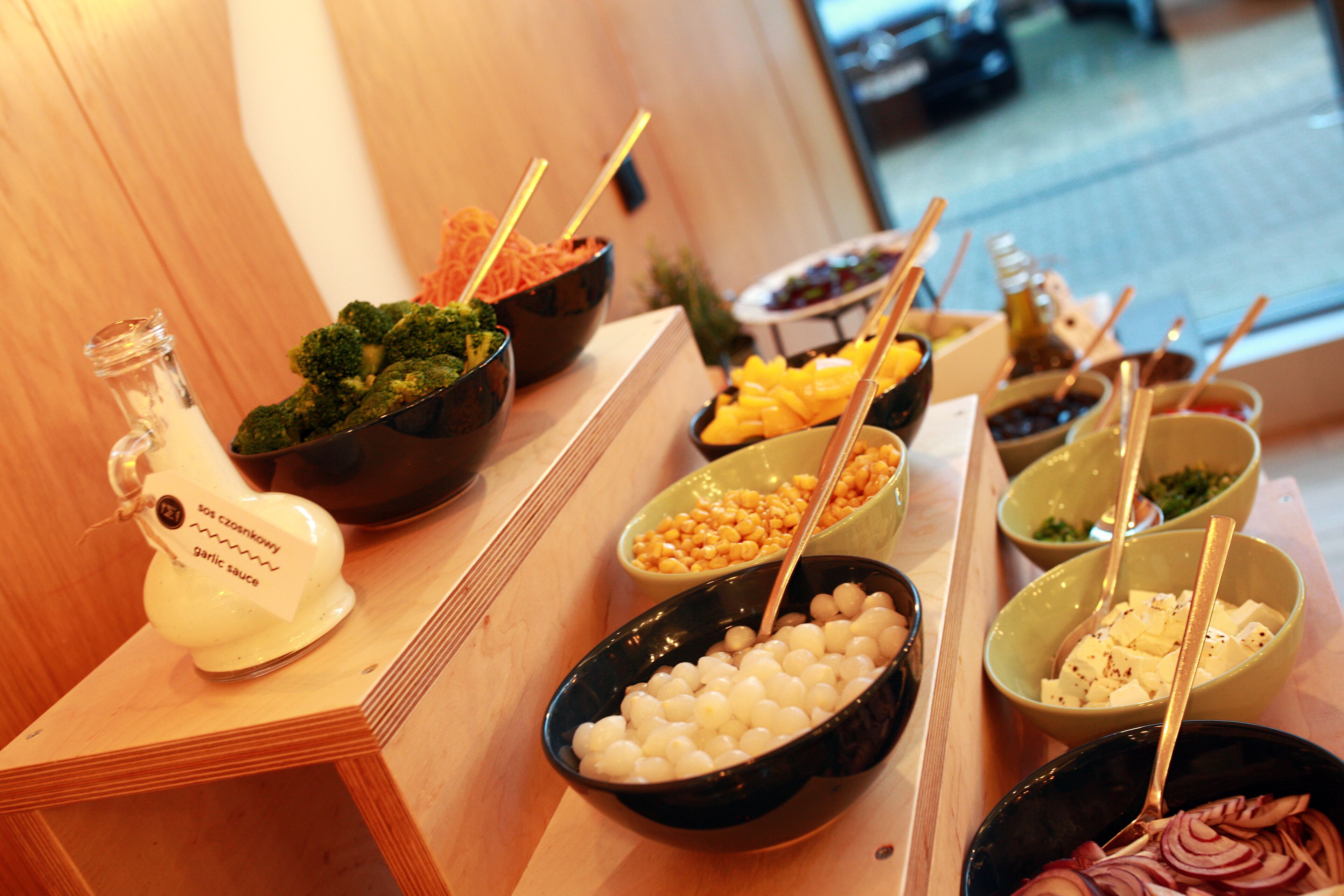 Un buffet proposant divers plats, notamment des brocolis, du fromage et d’autres aliments.