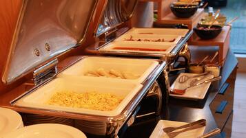 Een buffetopstelling met diverse gerechten en bestek.