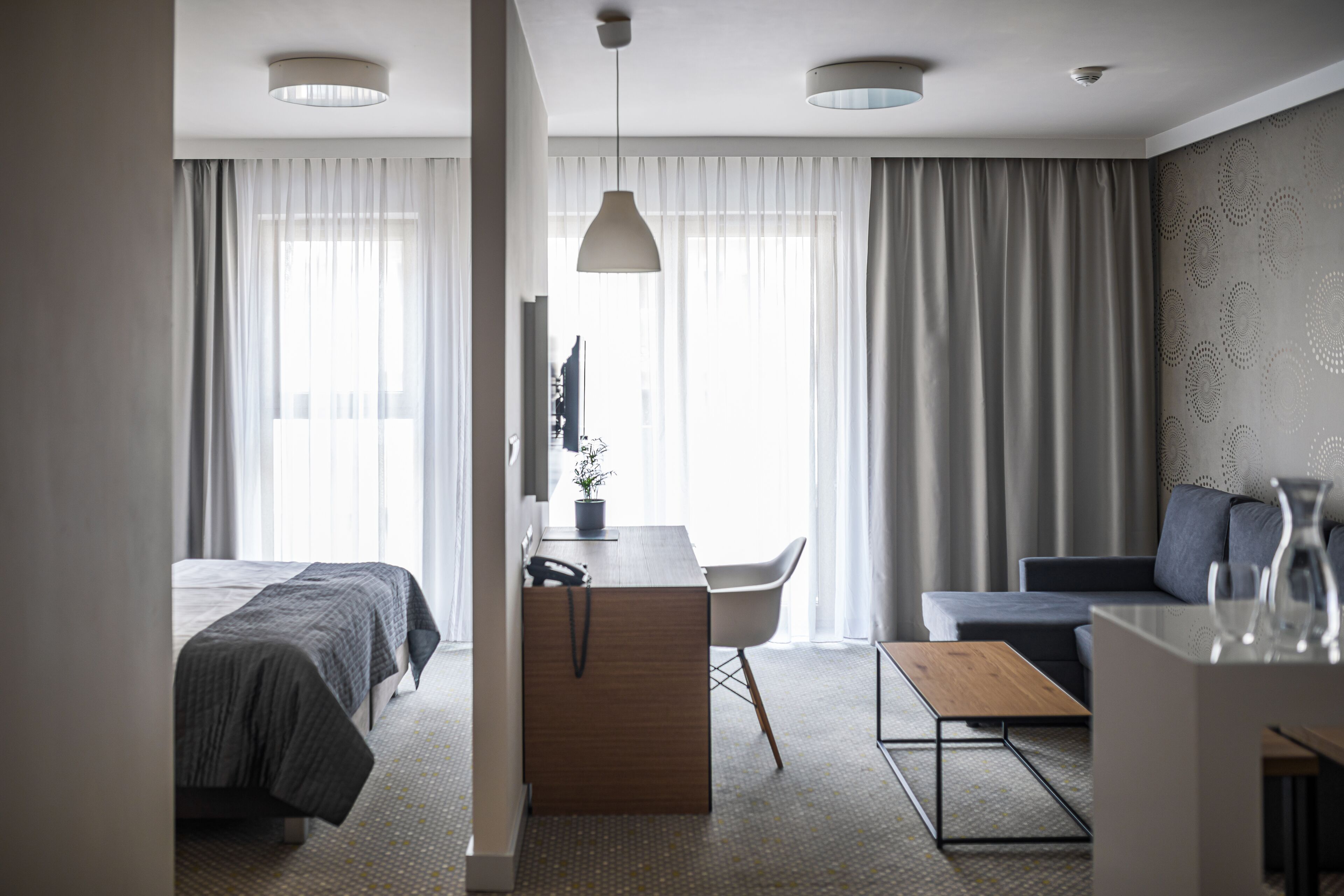 Une chambre d’hôtel moderne équipée d’un lit, d’un bureau, d’un canapé et d’une table à manger.