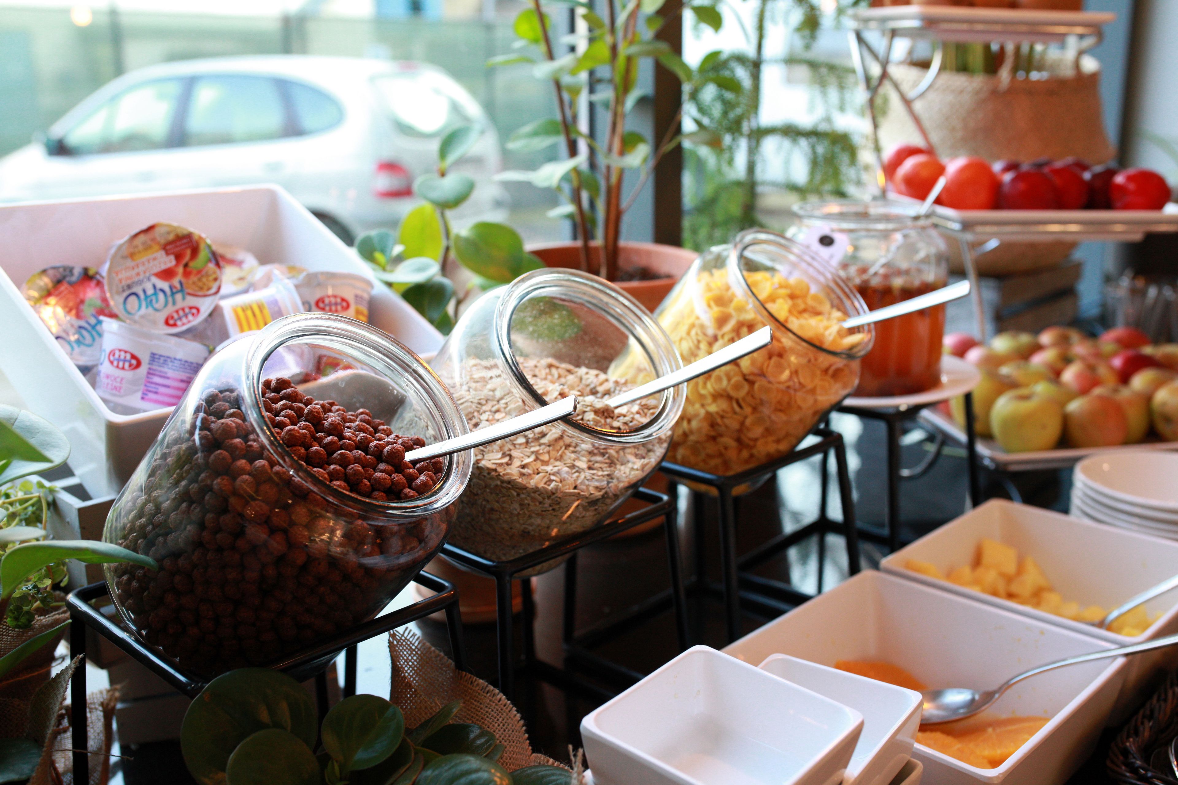 Buffet amb diverses opcions gastronòmiques, com ara fruita, cereals i productes lactis.