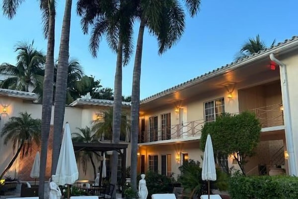 Una piscina al aire libre, sombrillas, tumbonas