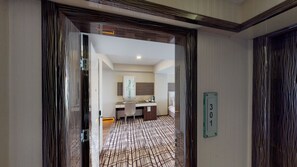 A hotel room with a modern design, featuring a desk, chair, and a bed. A bathroom with a sink and mirror is visible in the background. - Green Prusa Hotel (Bursa)