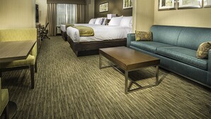 A hotel room with a bed, a sofa, a desk, and a chair.