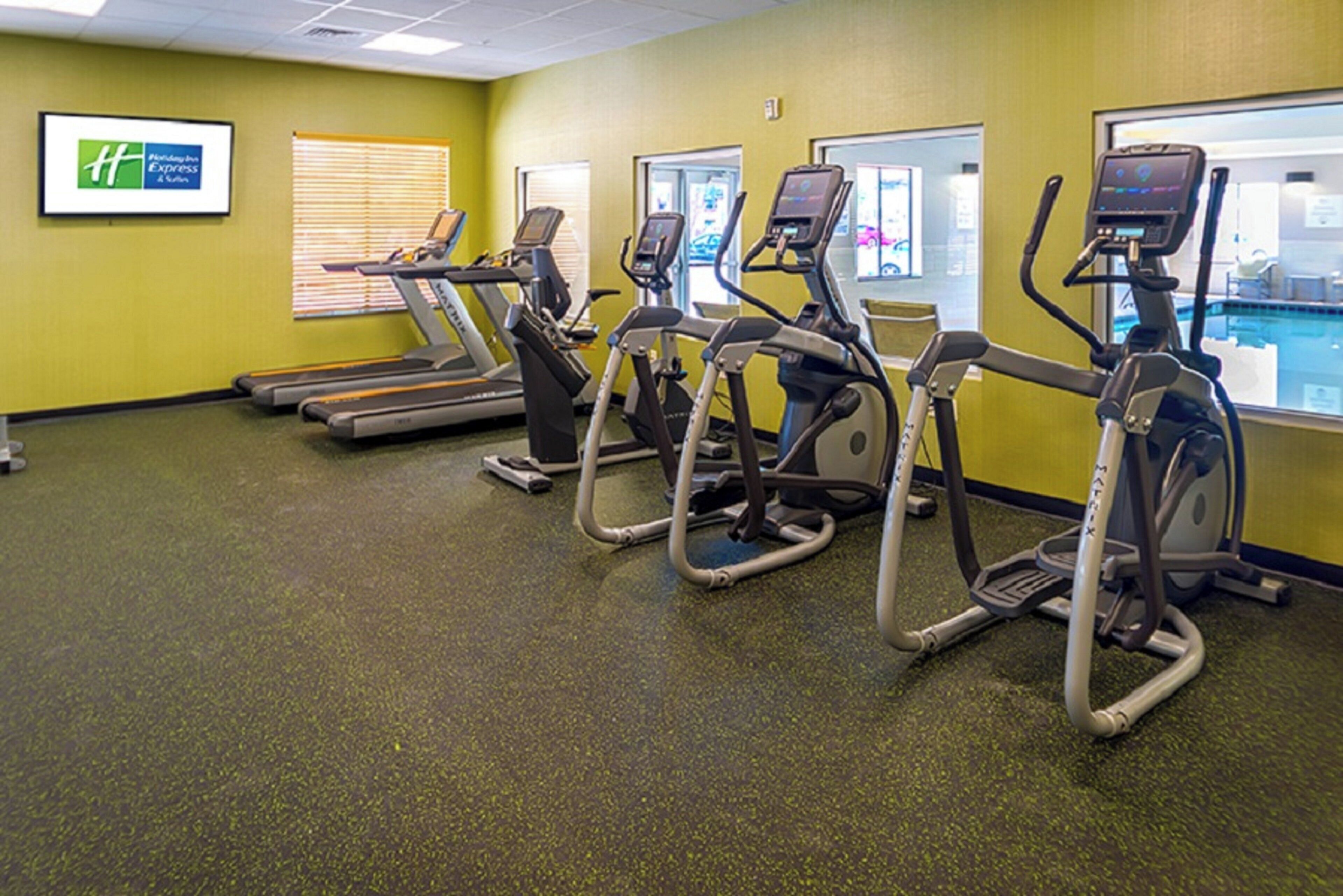 Une salle de sport équipée de tapis de course et d’appareils de musculation elliptique.