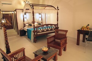 Un dormitorio con cama con dosel, muebles de madera y una cesta de frutas sobre una mesita de noche.