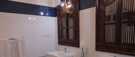 A bathroom with two sinks, a mirror, and a towel rack.