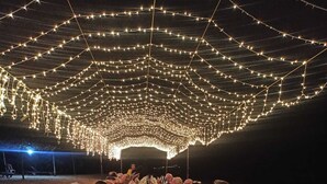 A long dining table set for a formal outdoor meal under a tent, surrounded by guests. - Wunderbar Beach Hotel (Bentota)