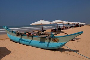 Playa privada, arena blanca, sillas reclinables de playa, sombrillas