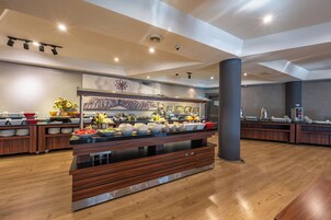Una cocina moderna con una isla central, armarios de madera y diversos alimentos exhibidos en la encimera.
