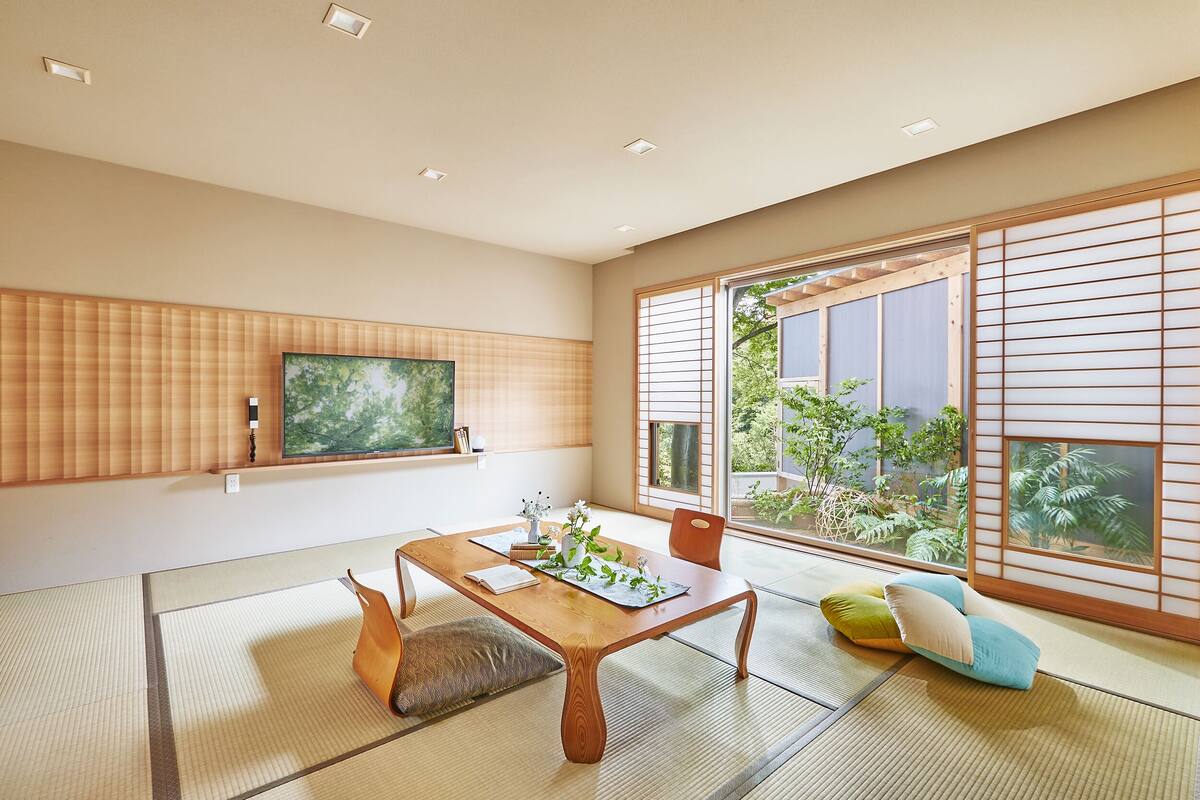 A traditional Japanese room with tatami flooring, a low wooden table, and shoji screens.