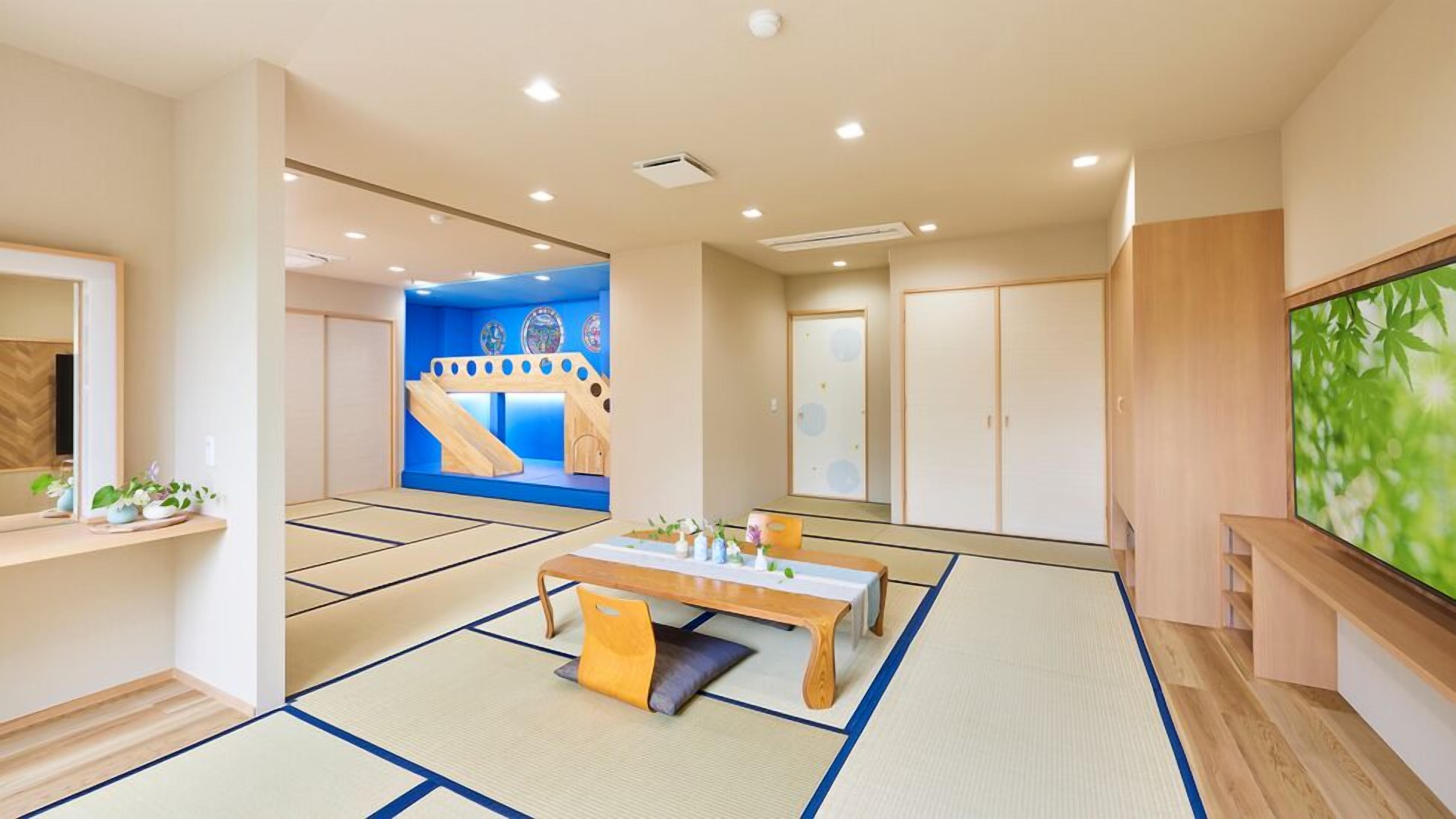 A traditional Japanese-style room with tatami flooring, a low table, and a sliding door.