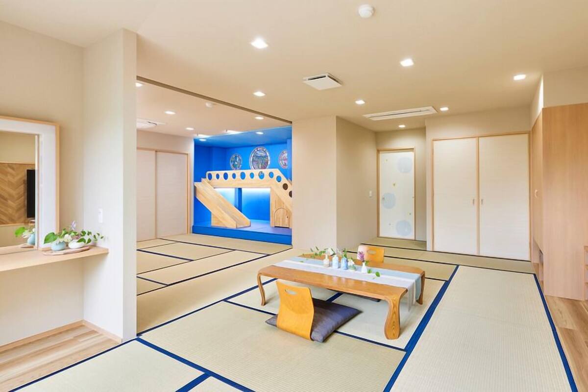 A traditional Japanese-style room with tatami flooring, a low table, and a sliding door.