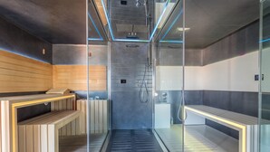 A modern sauna with glass walls, wooden benches, and a metal floor. - Mercure Golf Cap d'Agde (Agde)