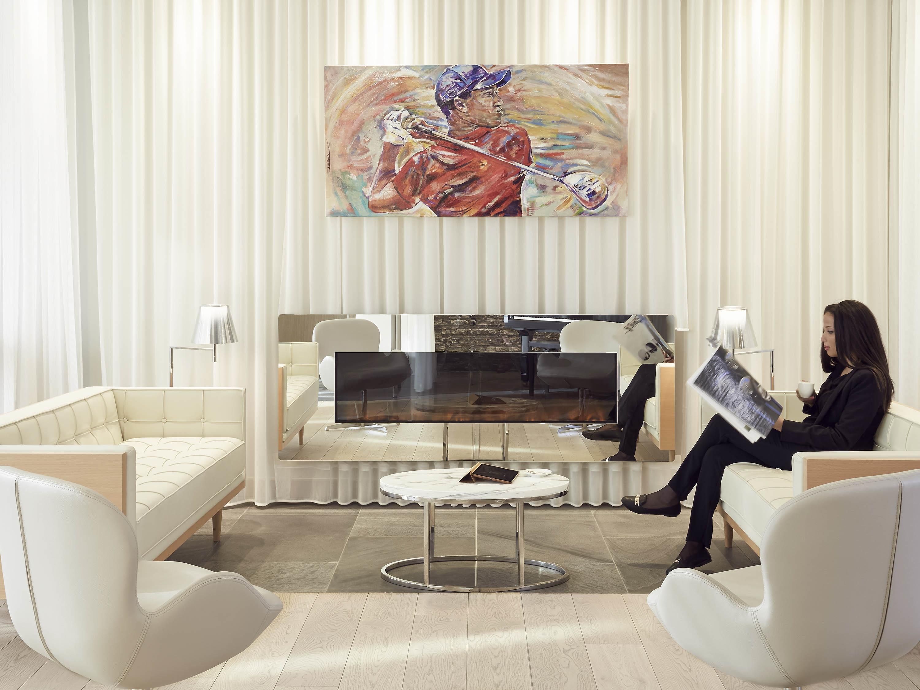 Uma sala de estar moderna com um sofá, uma mesa de centro e um quadro na parede.