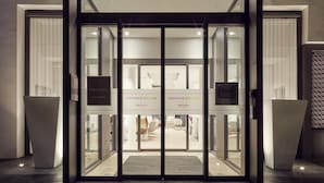 The entrance to the Mercure Hotel with a glass door, a sign above the door, and a reception area visible inside. - Mercure Golf Cap d'Agde (Agde)