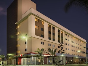 A multi-story hotel with a flat facade, large windows, and a parking area with a covered entrance. - ibis Porto Alegre Assis Brasil (Porto Alegre)