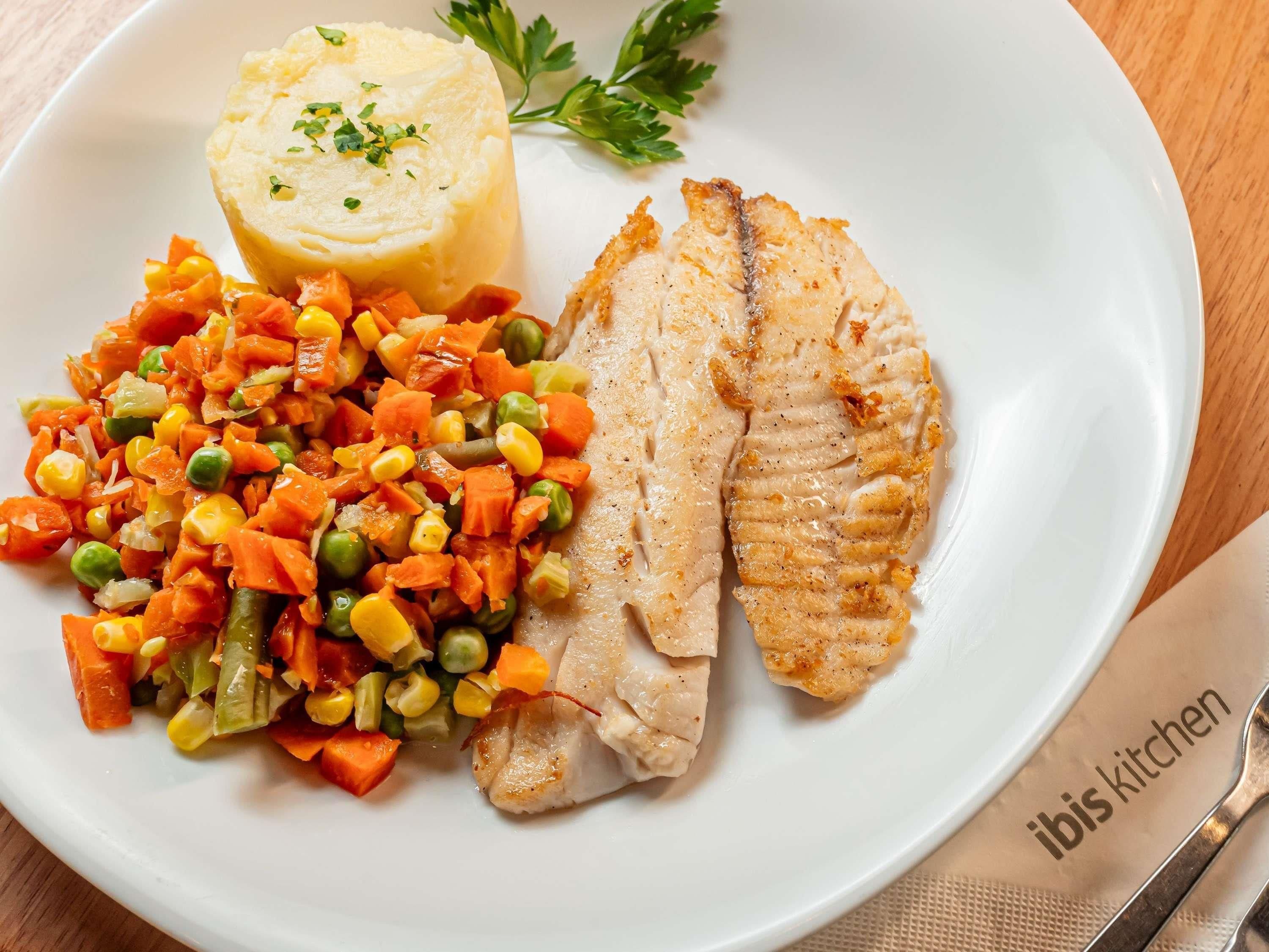 Prato com peixe, purê de batata e legumes variados.
