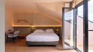 Une chambre à coucher moderne avec un grand lit, un bureau et une chaise.