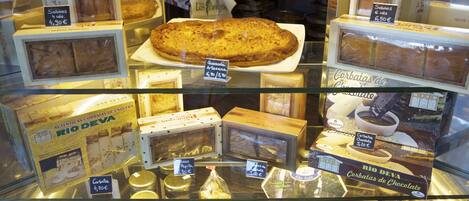 Una vitrina con distintos productos alimenticios, como bombones en cajas y frascos de conservas.