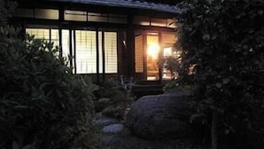 En traditionell japansk byggnad med skjutdörrar och en trädgårdspromenad.