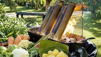 Una parrilla con verduras y hojas de plátano.