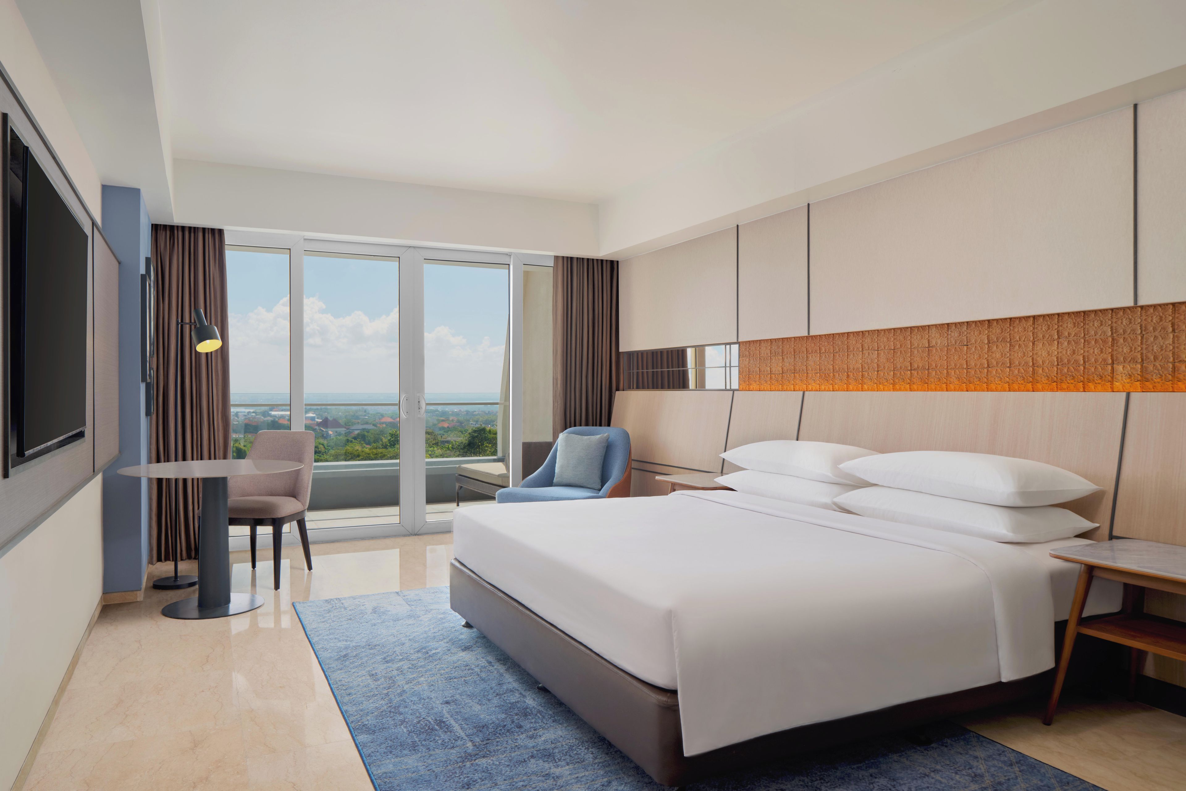 Una habitación de hotel con una cama grande, un escritorio, una silla y un televisor.
