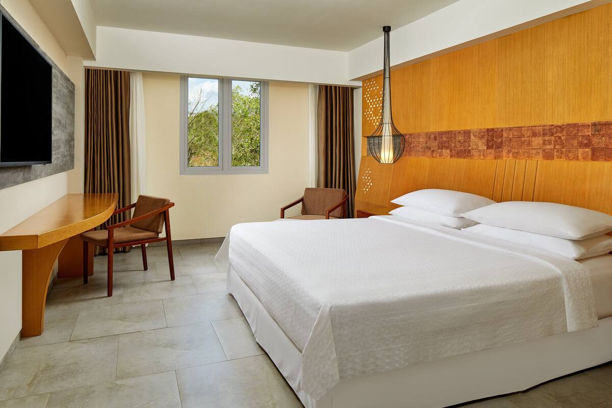 Kamar Deluks, 1 Tempat Tidur King, pemandangan halaman | Minibar, brankas, meja kerja, dan tirai kedap cahaya