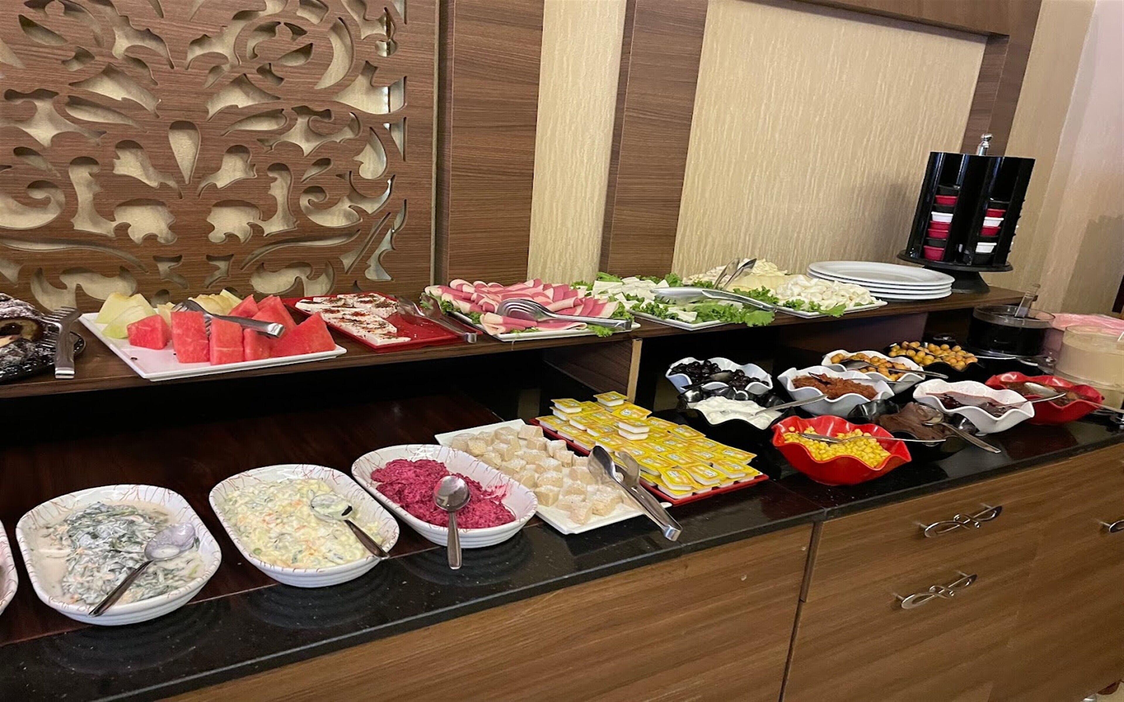 A buffet with various food items and utensils.