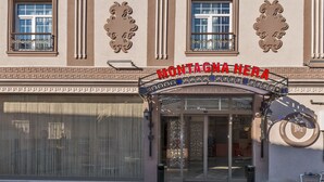 Entrada de teatro con decoraciones ornamentales y un letrero que dice "MONTAGNA HERA".