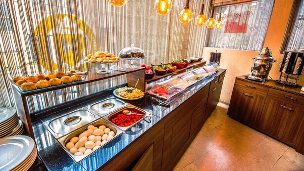 Un bufé con diferentes opciones de comida y una estación de café.