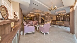 Un vestíbulo amplio con asientos cómodos, un mostrador de recepción e iluminación decorativa.