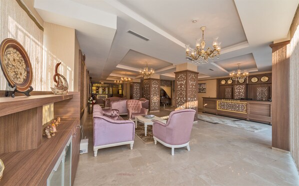 A spacious lobby with plush seating, a reception desk, and decorative lighting.