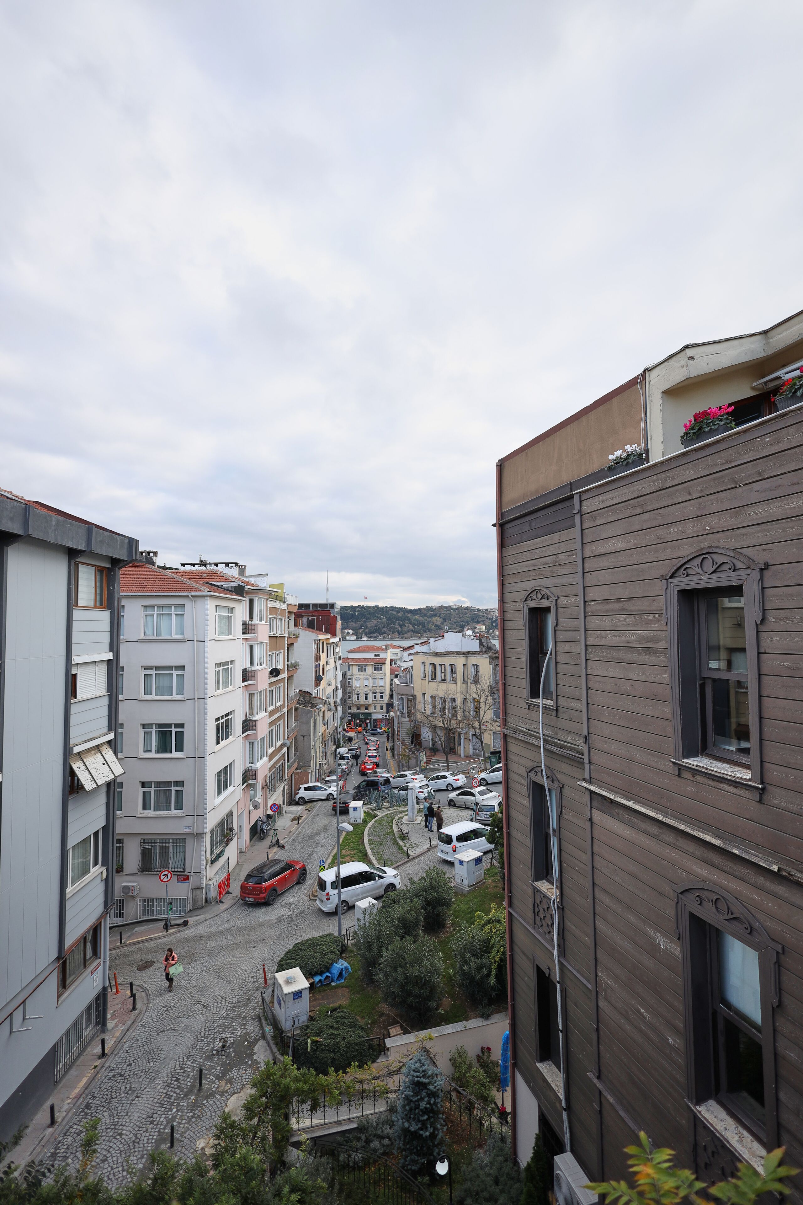 A cobblestone street lined with multi-story buildings, some with balconies and windows.