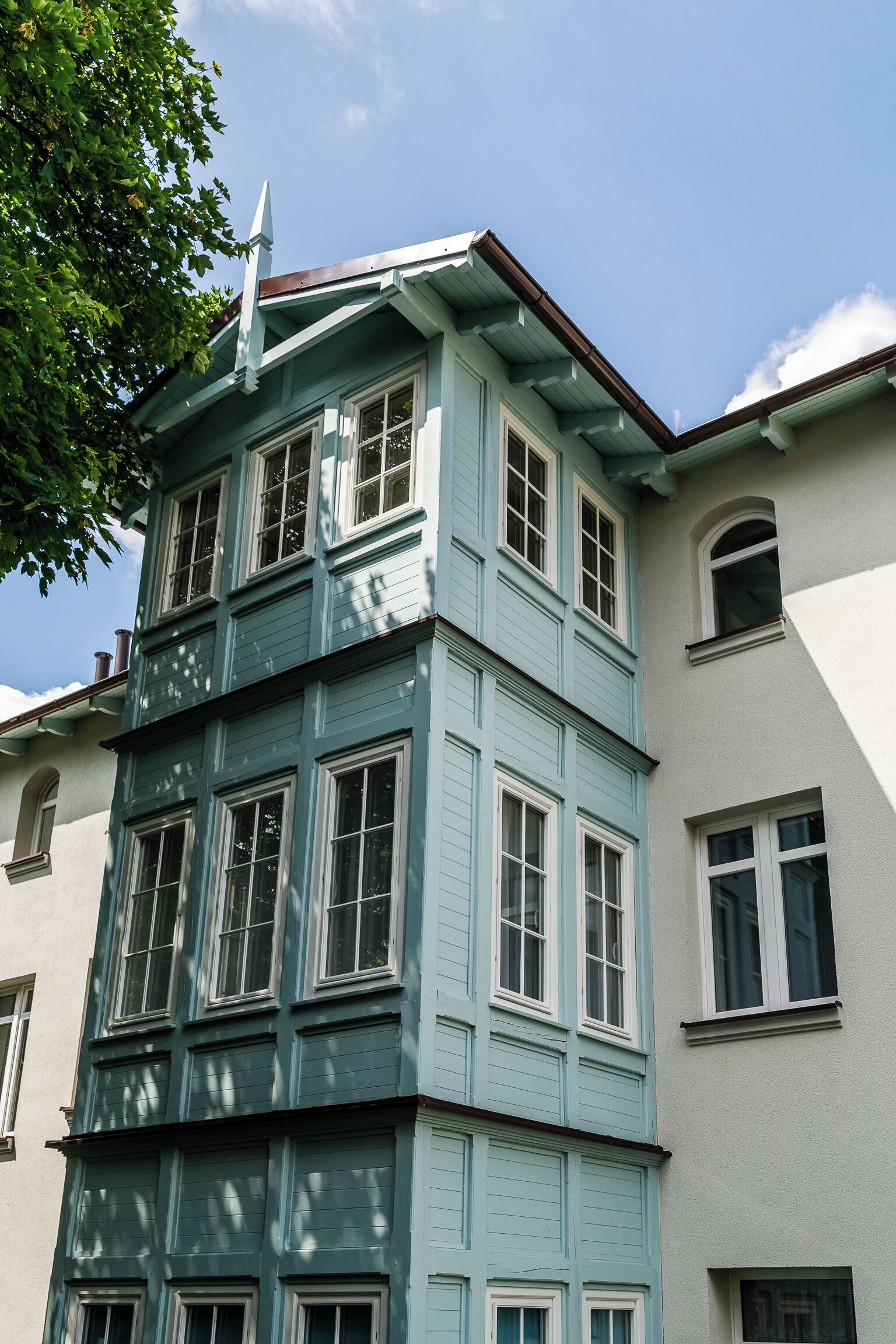 Un immeuble à plusieurs étages, doté d’une façade bleue distinctive et de bordures blanches.