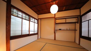 A traditional Japanese room with tatami flooring, sliding doors, and a hanging light fixture. - Kyomachiya Shokokuji-an (Kyoto)