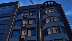 A multi-story hotel with a curved facade, large windows, and a ground-level entrance with outdoor seating. - The Residence Suite Hotel (Addis Ababa)