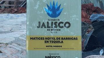 Un letrero promocional del Hotel Matices de Barricas en Jalisco, México, que destaca su reconocimiento como el mejor hotel del estado para 2025.