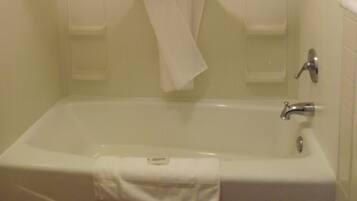 A bathroom with a bathtub, a shower curtain, and a towel rack.